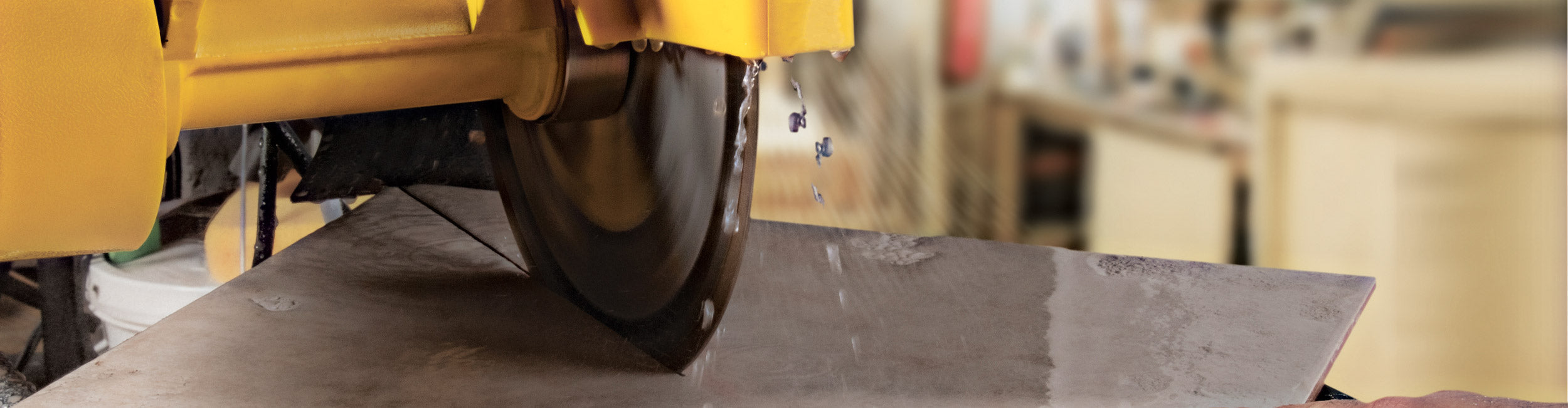 Close-up of a QEP wet tile saw diagonally cutting a square tile