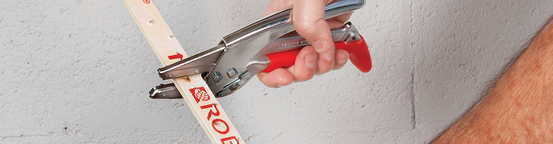 Carpet installer using a ROBERTS Professional 2" Strip Cutter to cut tack strip