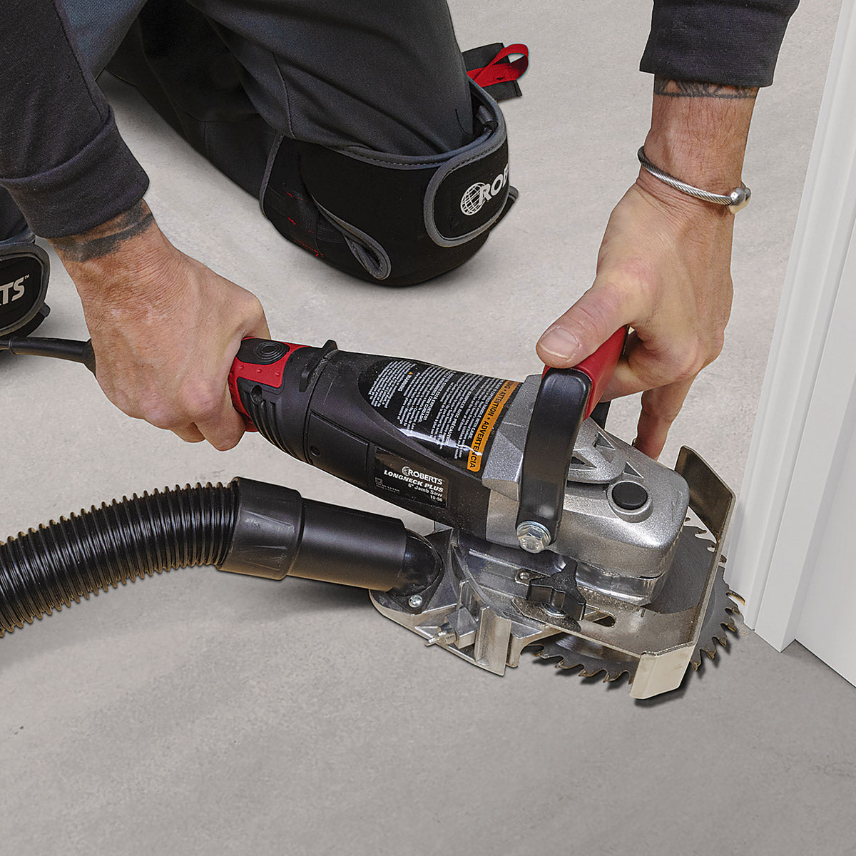 Installer using ROBERTS Longneck Plus 6" Jamb Saw to cut a door jamb while wearing ROBERTS knee pads