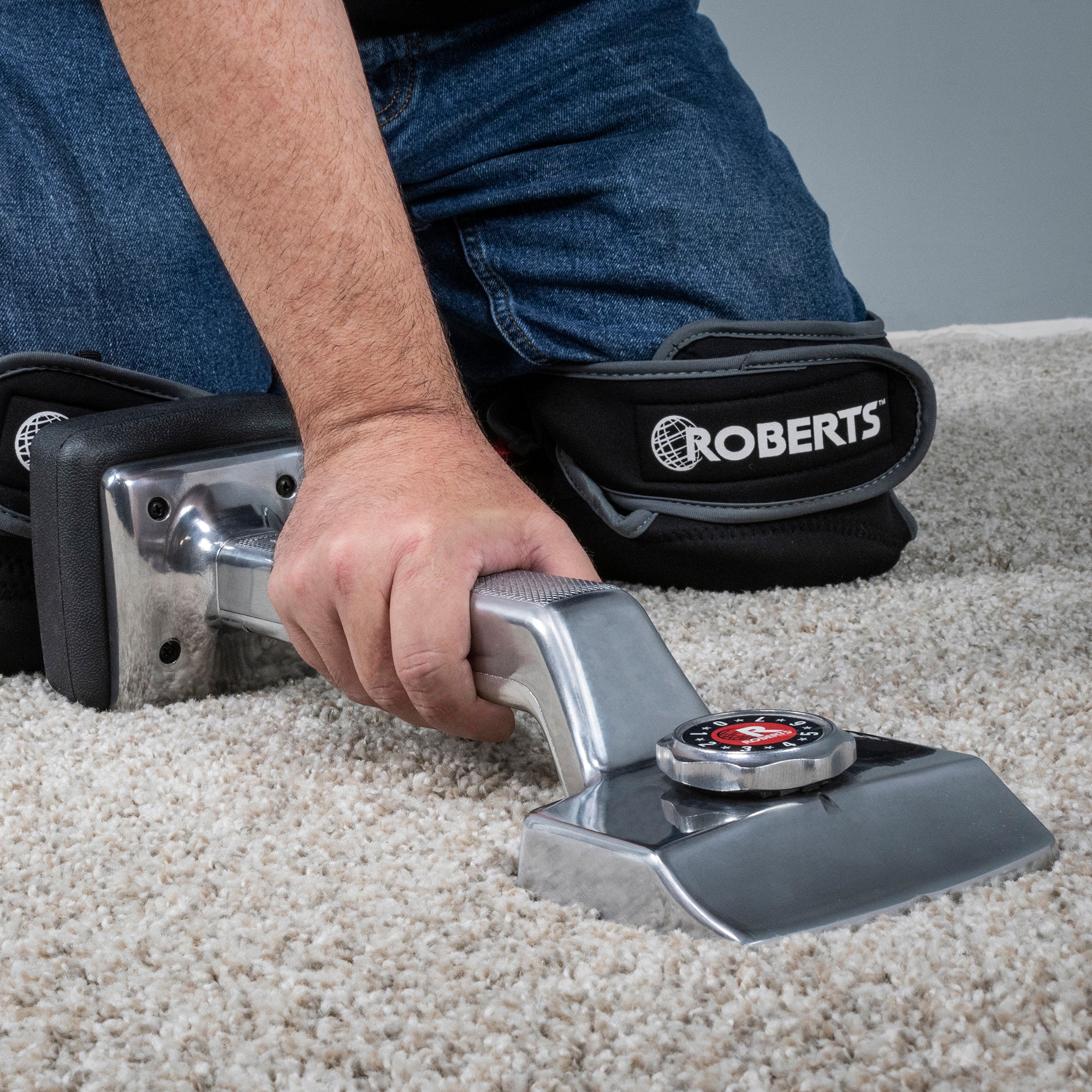 Carpet installer using The General knee kicker while wearing ROBERTS knee pads