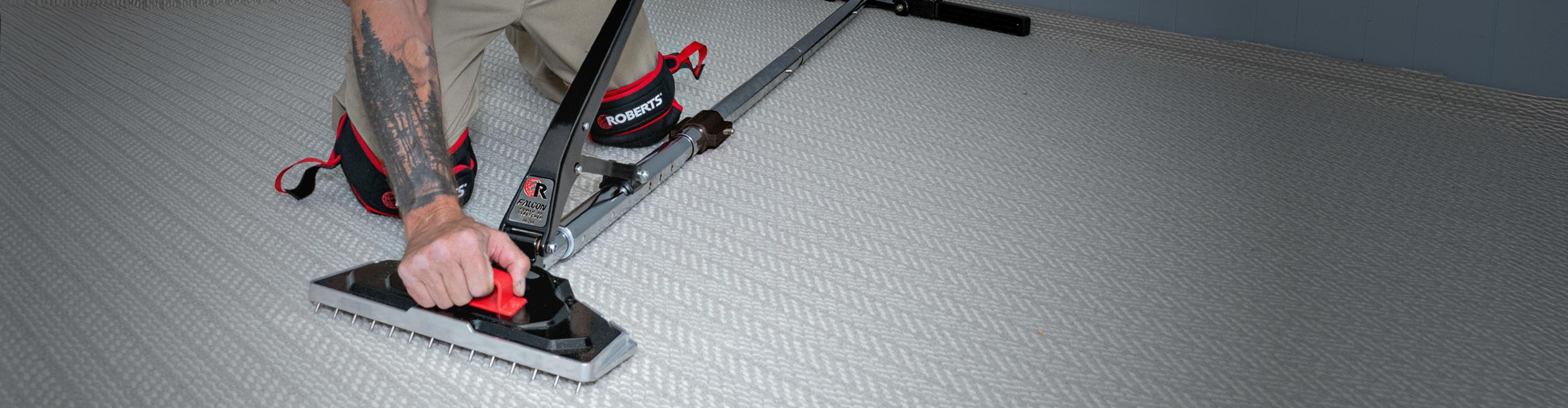 Close-up of ROBERTS Falcon Power 44 Stretcher being used to stretch carpet during installation