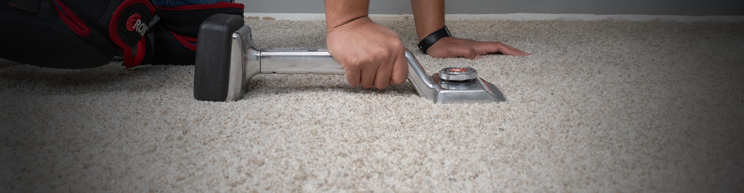 Installer using ROBERTS THE GENERAL Knee Kicker to apply tension to carpet during installation