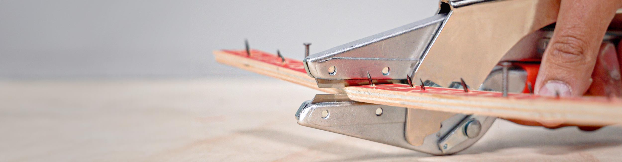 Close-up of installer using ROBERTS Professional 2" Strip Cutter to cut tack strip