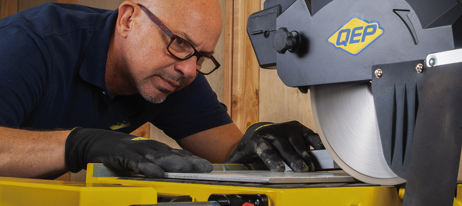 QEP wet tile saw in use, by person wearing QEP SureGrip Tiler’s Gloves