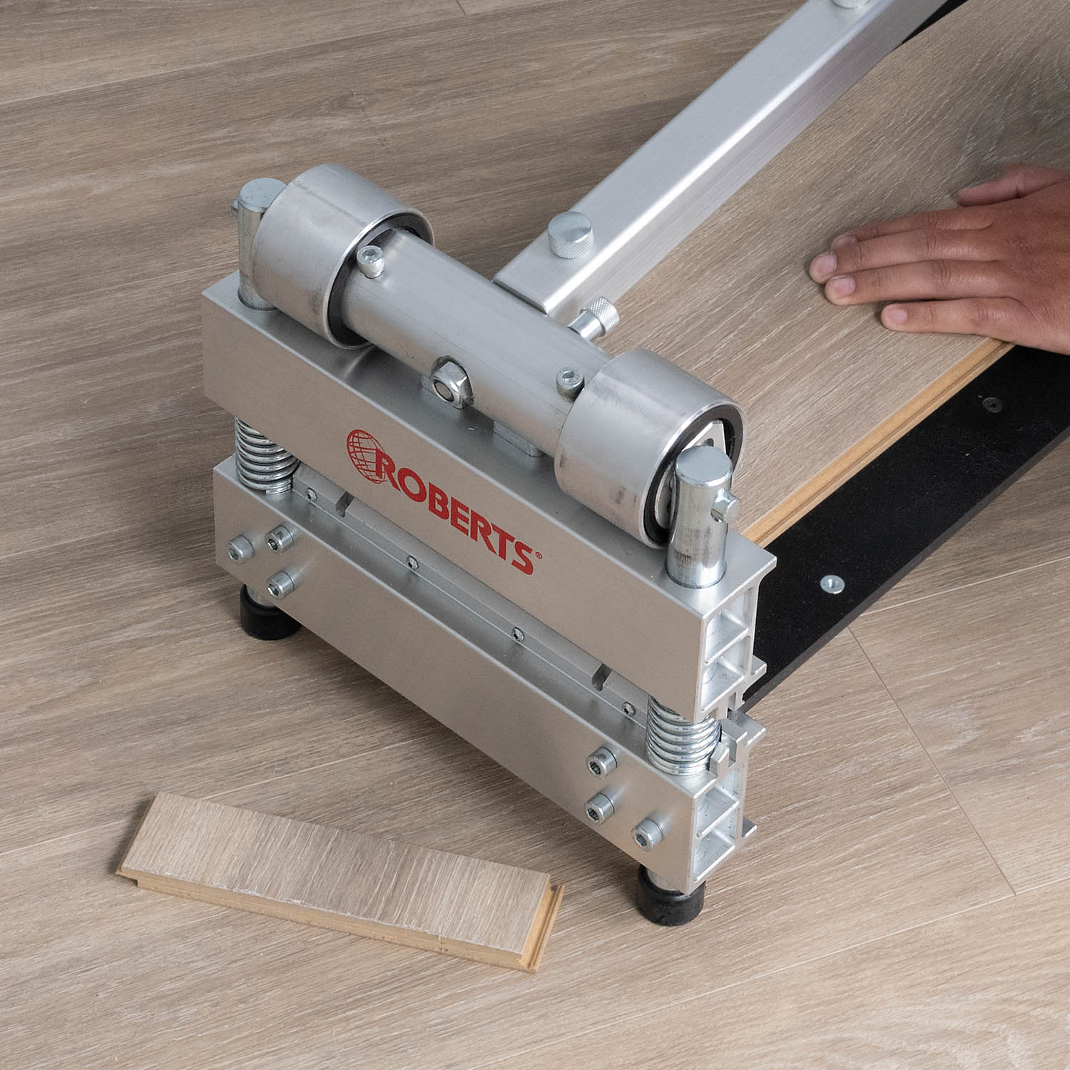 Installer using the ROBERTS 10-911 9" Multi-Floor Cutter to cut plank of flooring