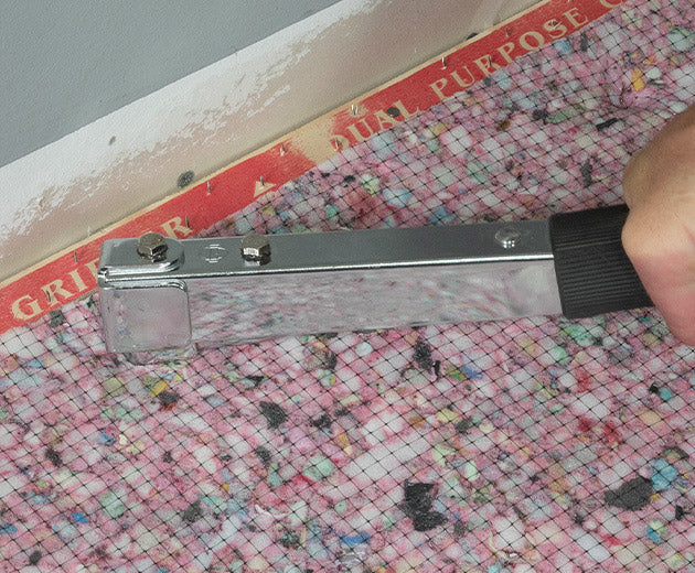 ROBERTS Staple Hammer in use on carpet padding next to ROBERTS tack strip